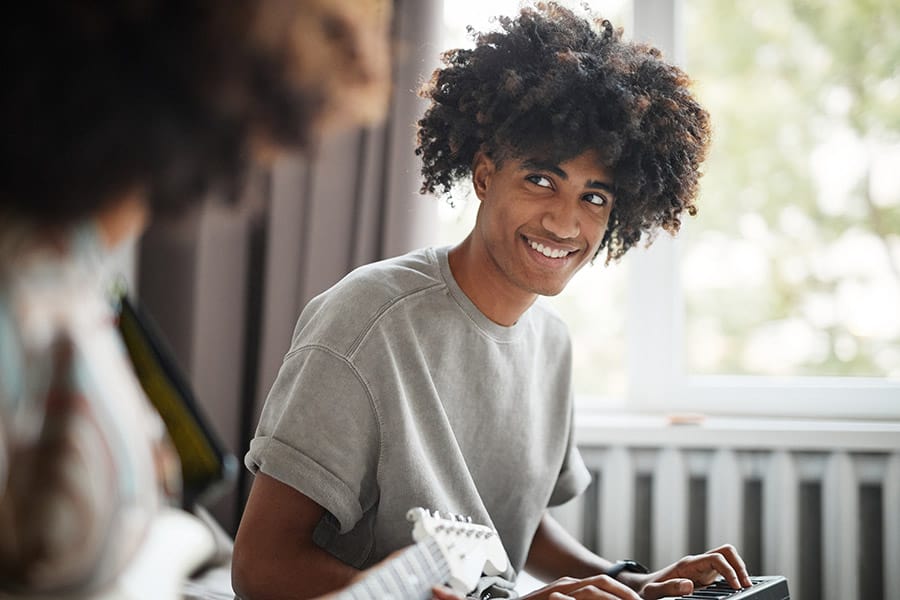 Portrait of young African-American musician composing music at home